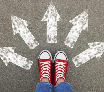 کفش های کتانی قرمز روی زمین آسفالت با فلش های رنگی