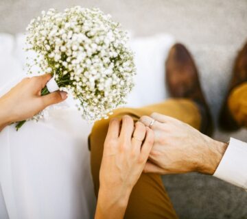 عروس و داماد کنار هم با دست گل عروسی