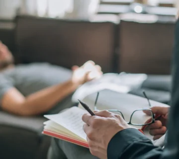 مرد دراز کشیده روی کاناپه جلوی روانکاو