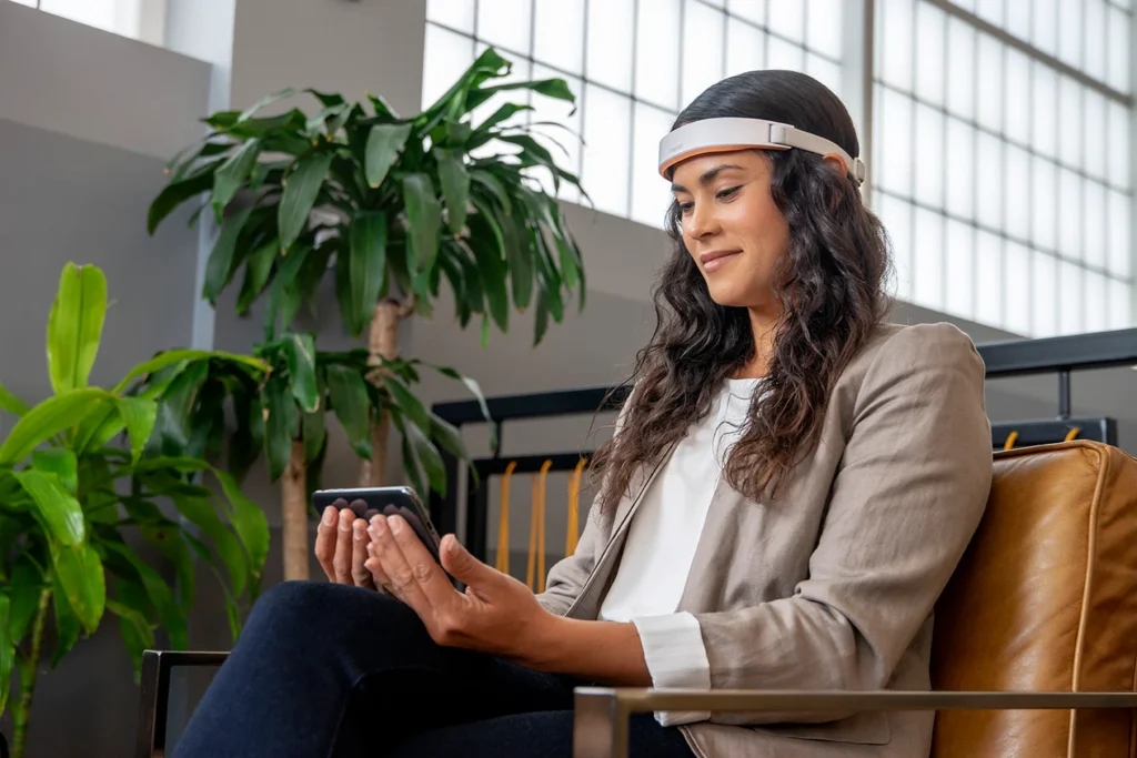 زن در حال تماشای موبایل و ابزار روی پیشانی