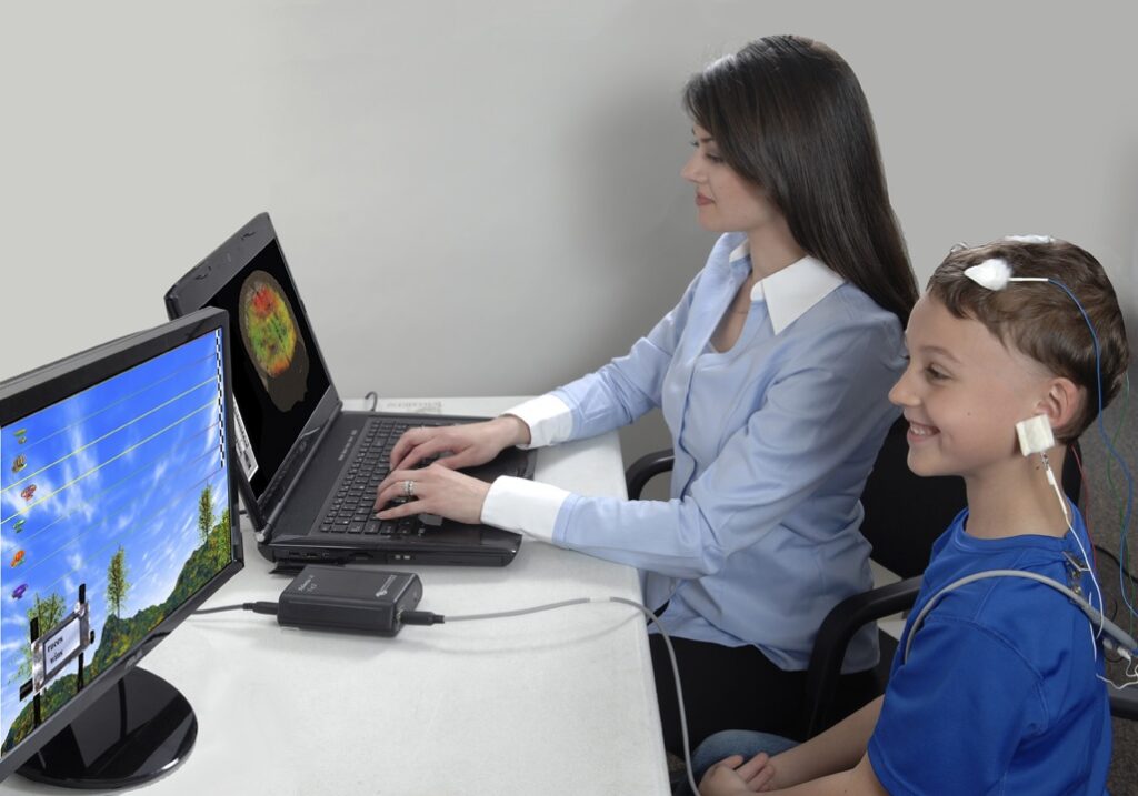 متخصص مغز و کودک با حسگرهای مغز پشت مانیتور