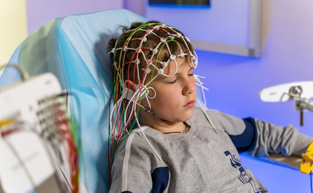 کودک با کلاه مغزی و سیم های متصل
